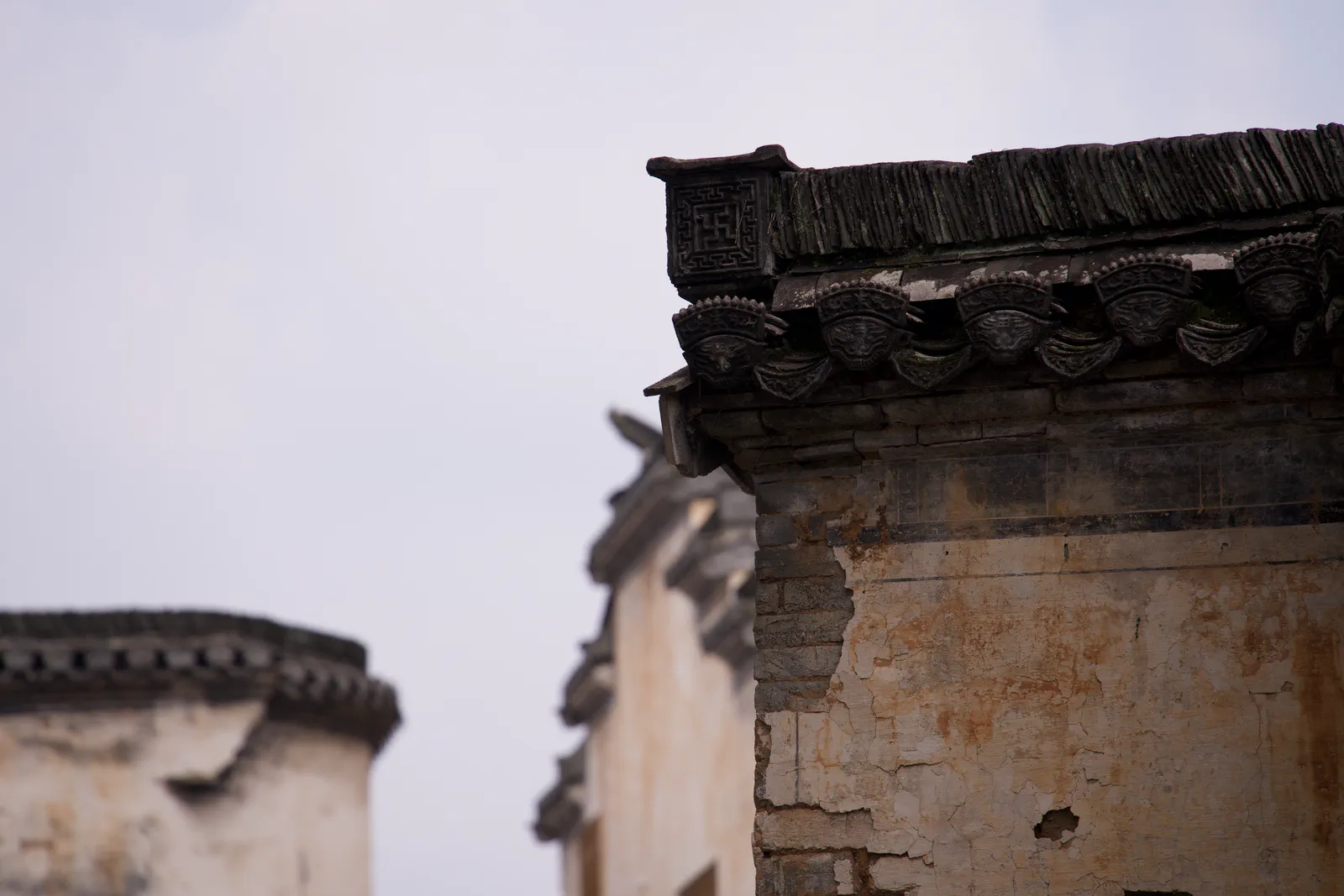 Layered tiled roofs and weathered plaster walls in Chengkan.