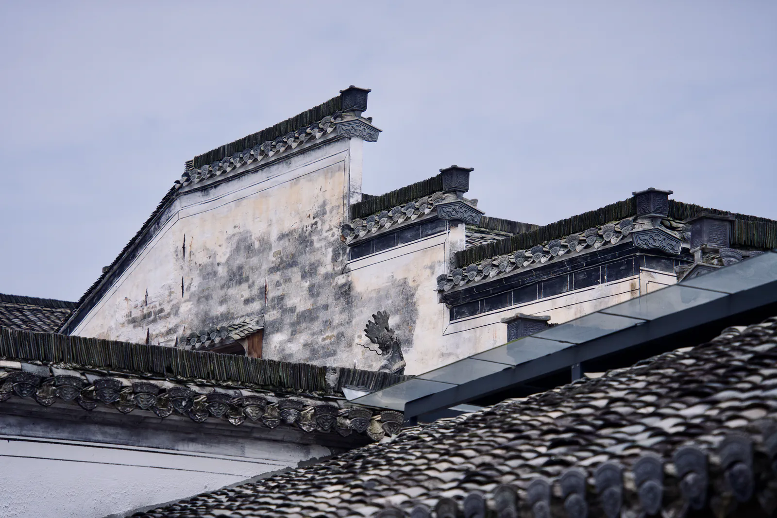 Stepped white gables rising above rows of grey roof tiles.