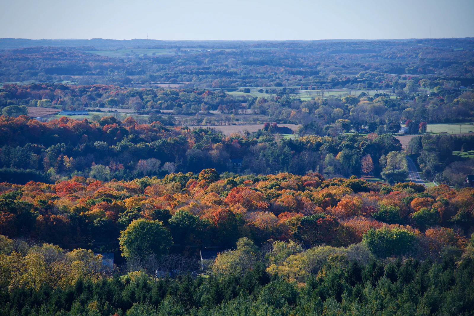 A wide view of colorful autumn trees and the countryside beyond.