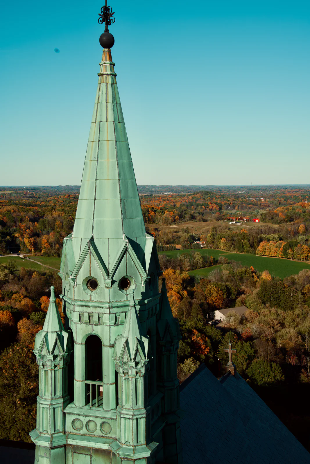 The Holy Hill church spire rising above a landscape of autumn trees.